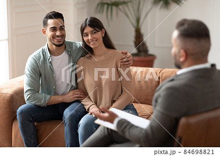 Happy couple reconciling at therapy session with therapists 84698821