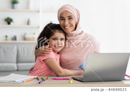 Happy Muslim Woman In Hijab And Her Little Daughter Posing At Home 84699025