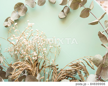 Bunch of dried flowers and eucaliptus branches on green background Bunch of dried flowers and eucaliptus branches on green background 84699906