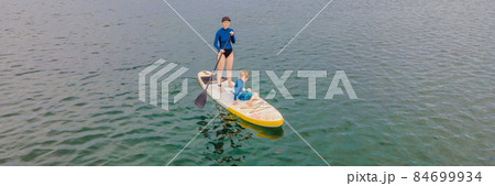 Mother and son paddling on stand up board having fun during summer beach vacation BANNER, LONG FORMAT Mother and son paddling on stand up board having fun during summer beach vacation BANNER, LONG FORMAT 84699934