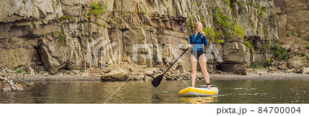 BANNER, LONG FORMAT Young women Having Fun Stand Up Paddling in the sea. SUP. Red hair girl Training on Paddle Board near the rocks BANNER, LONG FORMAT Young women Having Fun Stand Up Paddling in the sea. SUP. Red hair girl Training on Paddle Board near the rocks 84700004