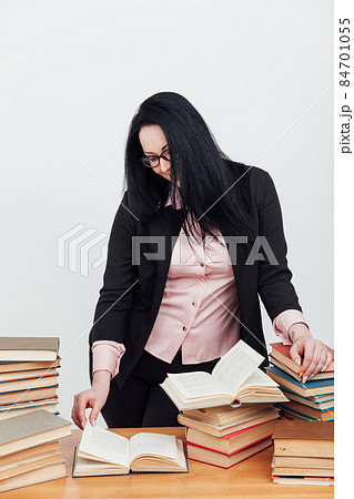 female teacher at a table with books for teaching 84701055