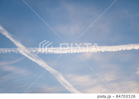 Twilight sky with effect of light pastel blue colors and trail of plane. Colorful sunset of soft clouds. 84703526