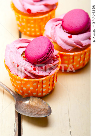 pink berry cream cupcake with macaroon on top pink berry cream cupcake with macaroon on top 84704366