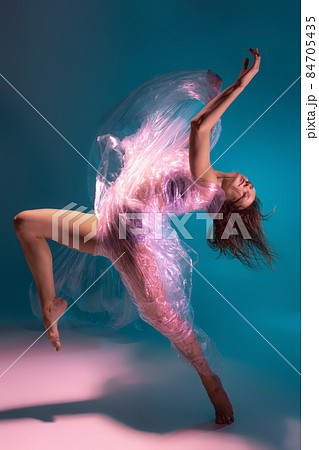 Solo performance. Beautiful flexible contemp dancer dancing with fabric isolated on gradient blue white background in neon light 84705435