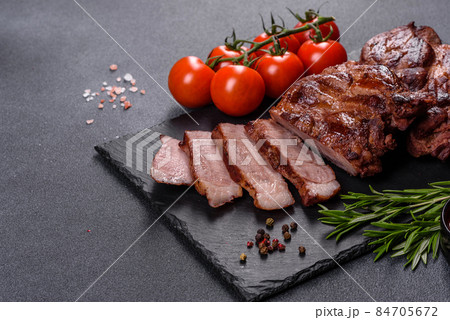 grilled beef steaks with spices on a dark cutting board 84705672