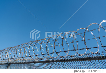barbwire perimeter fence. ensuring safety and security. jail wall. barbwire perimeter fence. ensuring safety and security. jail wall. 84705968