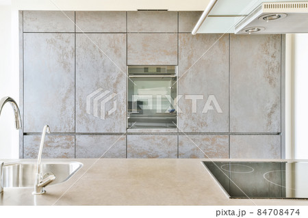 Interior of spacious light kitchen with modern furniture in light apartment 84708474