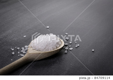 Wooden spoon with sea salt on a chalk board Wooden spoon with sea salt on a chalk board 84709114