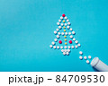 Creative Christmas tree made of pills on a blue background Holiday greeting card with space for text 84709530