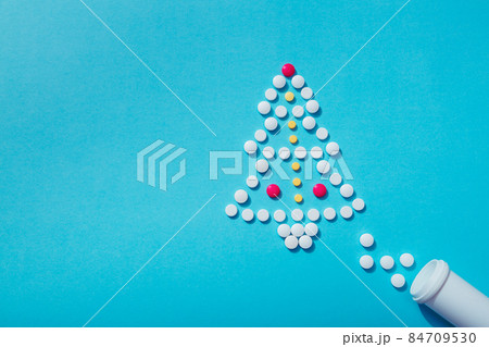 Creative Christmas tree made of pills on a blue background Holiday greeting card with space for text 84709530