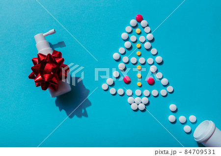 Creative Christmas tree made of pills on a blue background with nasal spray, prescription for sick 84709531
