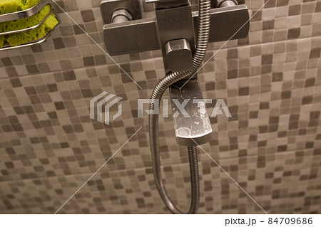 Water tap in the bathroom close-up. Hard water. Plaque on the tap from dirty water. 84709686