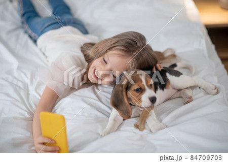 Smiling cute girl making photo with her funny pet 84709703