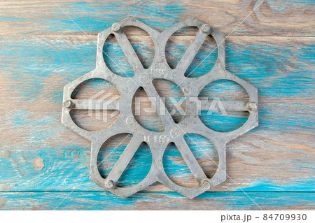 Old aluminum dumplings mold on blue wooden background. 84709930