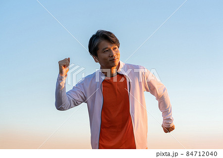 夕陽を浴びて走る中年男性の上半身 夕陽を浴びて走る中年男性の上半身 84712040
