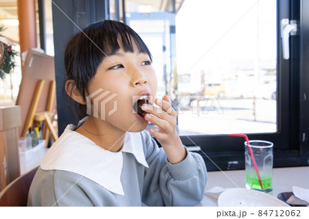 おやつのドーナツを食べる小学生の女の子 おやつのドーナツを食べる小学生の女の子 84712062