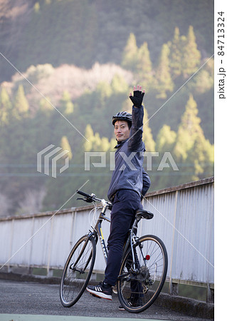 手を上げている男性サイクリスト 84713324