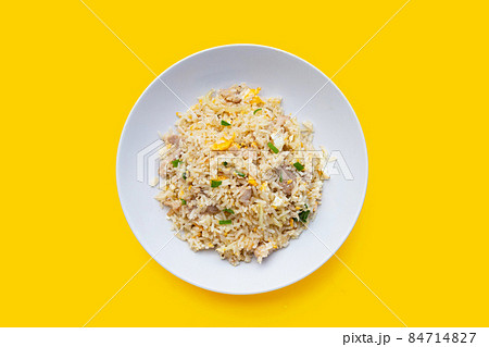 Fried rice in white plate on yellow background. Fried rice in white plate on yellow background. 84714827