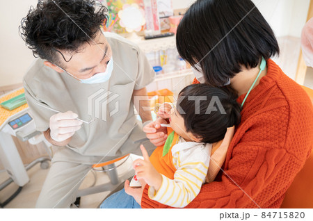 頑張って幼児の口を開けようとする小児歯科医5 頑張って幼児の口を開けようとする小児歯科医5 84715820