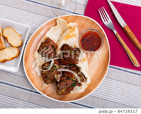Grilled pork meat shashlik with sliced onion 84716317