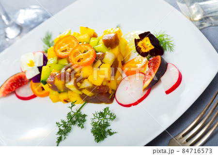 Delicious tartare of tuna with mango, avocado and fig, served with flower 84716573