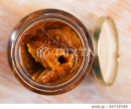 Open jar with pickled red pine mushrooms 84716589