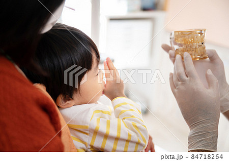 母親に模型を使って子どもの歯を説明する小児歯科医のイメージ 84718264