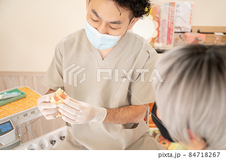 診察室で入れ歯の調子を合わせる歯科医	 84718267