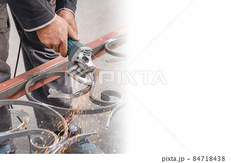 Metal grinding with angle grinder. Sparks fly on the sides. Male hand and instrument close-up. Banner, copy-space. Metal grinding with angle grinder. Sparks fly on the sides. Male hand and instrument close-up. Banner, copy-space. 84718438