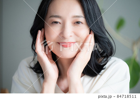 お肌の調子を気にして微笑む美しい日本人女性 クローズアップ 正面 カメラ目線 お肌の調子を気にして微笑む美しい日本人女性 クローズアップ 正面 カメラ目線 84718511