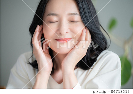 お肌の調子を気にして微笑む美しい日本人女性クローズアップ 　正面　カメラ目線 84718512