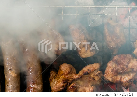 Top view of sausage and meat grilling on barbecue 84721713