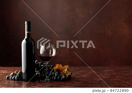 Red wine and grapes on a brown background. Red wine and grapes on a brown background. 84722890
