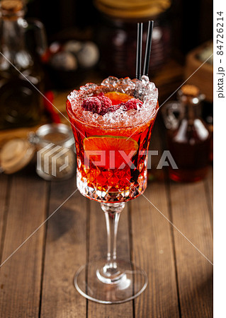 Sweet red berry alcohol cocktail in a fancy glass Sweet red berry alcohol cocktail in a fancy glass 84726214