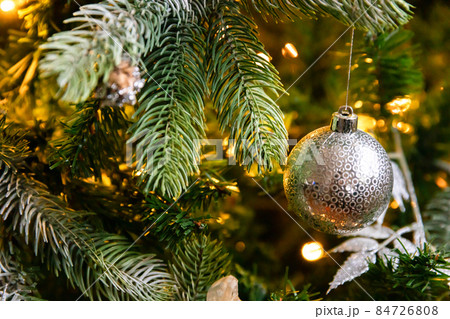Classic Christmas decorated New year tree. Christmas tree with wite and silver decorations, ornaments toy and ball. Modern classical style interior design apartment. Christmas eve at home Classic Christmas decorated New year tree. Christmas tree with wite and silver decorations, ornaments toy and ball. Modern classical style interior design apartment. Christmas eve at home 84726808