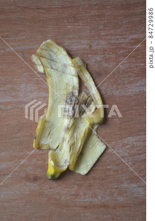 Banana peels are on a piece of wood.  84729986