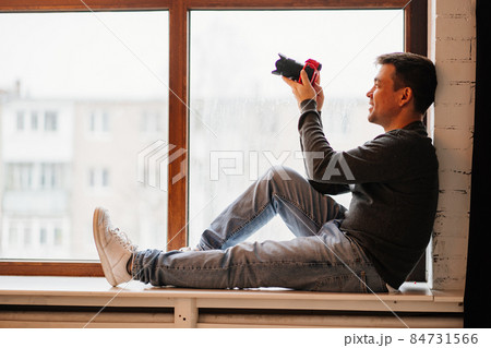 photographer sits on windowsills and takes pictures. training in photography.  84731566