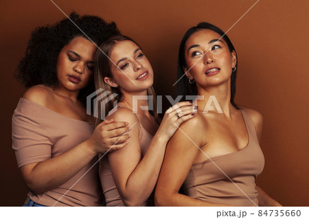 young pretty asian, caucasian, african woman posing cheerful together on brown background, lifestyle diverse nationality people concept young pretty asian, caucasian, african woman posing cheerful together on brown background, lifestyle diverse nationality people concept 84735660