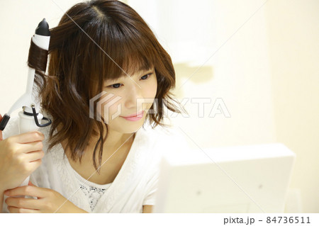 ヘアアイロンを使う女性 ヘアアイロンを使う女性 84736511