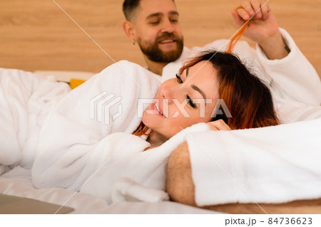 A man playing with a woman's hair 84736623