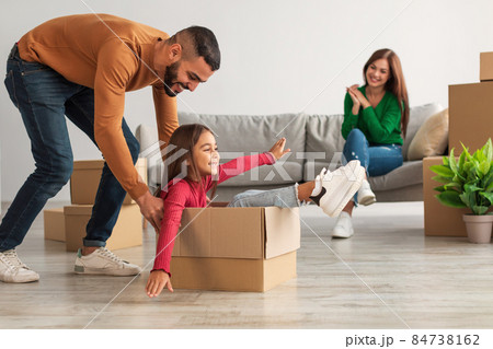 Happy arab family playing, celebrating relocation in new house 84738162