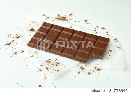 Tasty chocolate bar on paper on white background Tasty chocolate bar on paper on white background 84738942