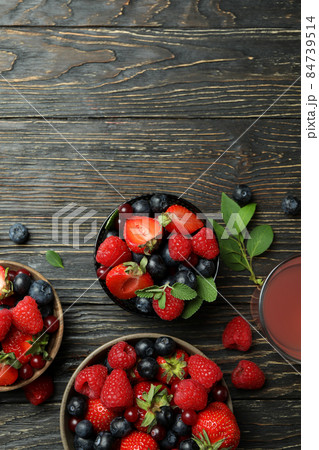 Bowls with berry mix and juice on wooden background Bowls with berry mix and juice on wooden background 84739514
