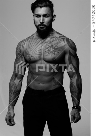 Muscular shirtless tattooed guy in studio Muscular shirtless tattooed guy in studio 84742030
