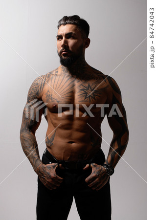 Muscular shirtless tattooed guy in studio 84742043