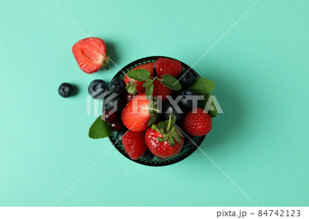 Bowl with berry mix on mint background Bowl with berry mix on mint background 84742123