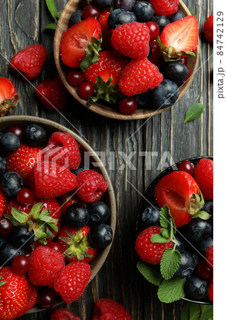 Bowls with berry mix on wooden background Bowls with berry mix on wooden background 84742129