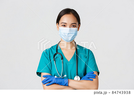 Covid-19, coronavirus disease, healthcare workers concept. Close-up of confident smiling, professional asian doctor, nurse in medical mask and rubber gloves ready for examination, white background Covid-19, coronavirus disease, healthcare workers concept. Close-up of confident smiling, professional asian doctor, nurse in medical mask and rubber gloves ready for examination, white background 84743938