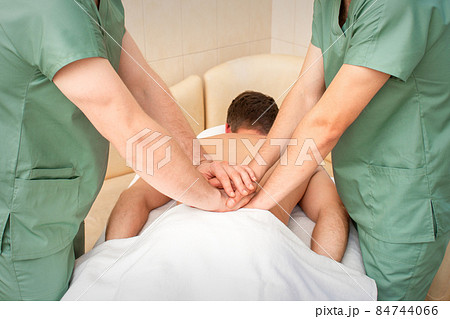 Young man receiving back massage in four hands in spa beauty salon. 84744066